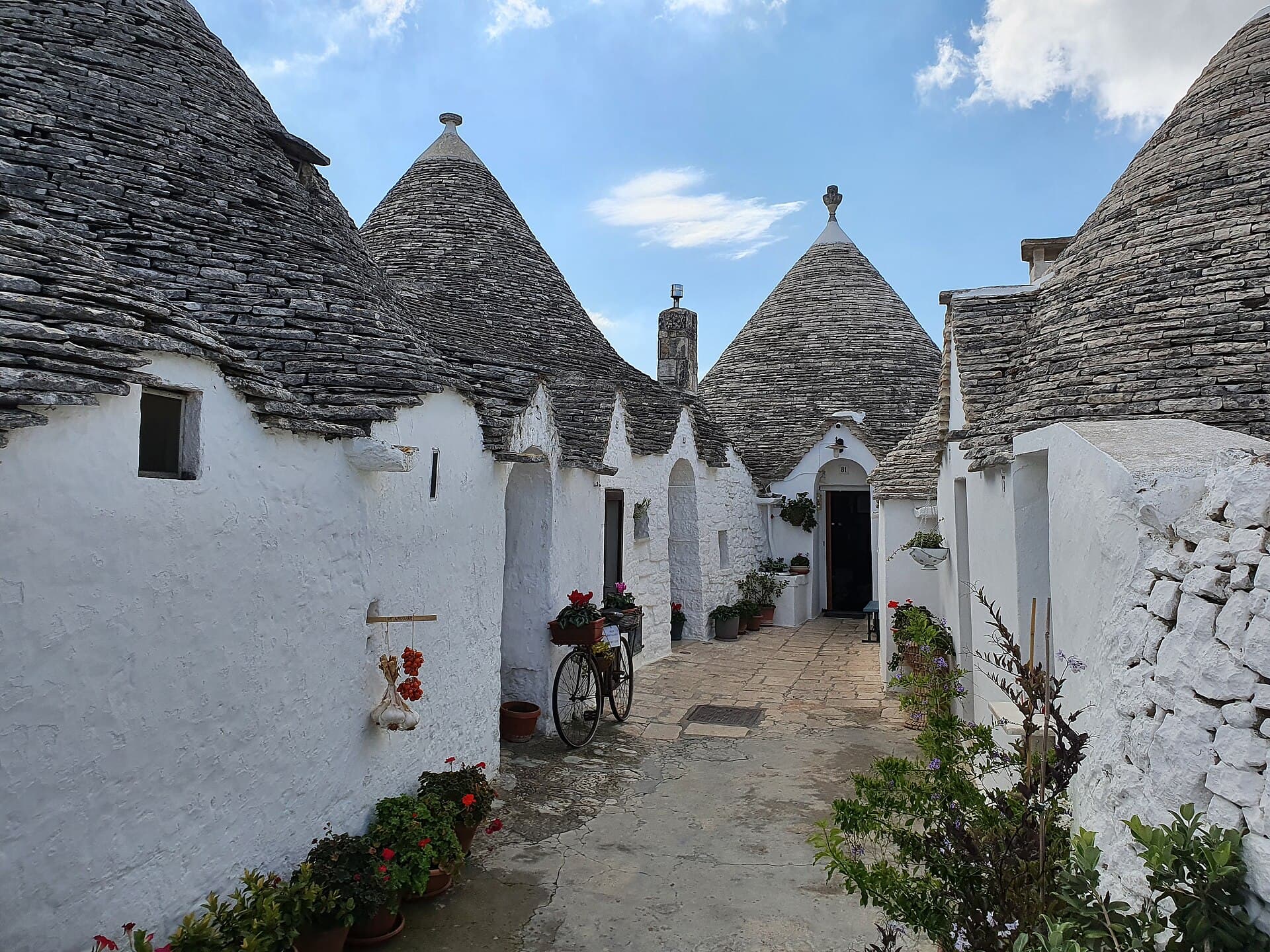 A lane of whitewashed trulli in Alberobello — Itria Valley, Puglia, Italy
